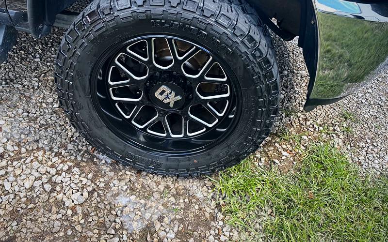 Cleaned black wheel and dressed off-road tire on a Ram truck